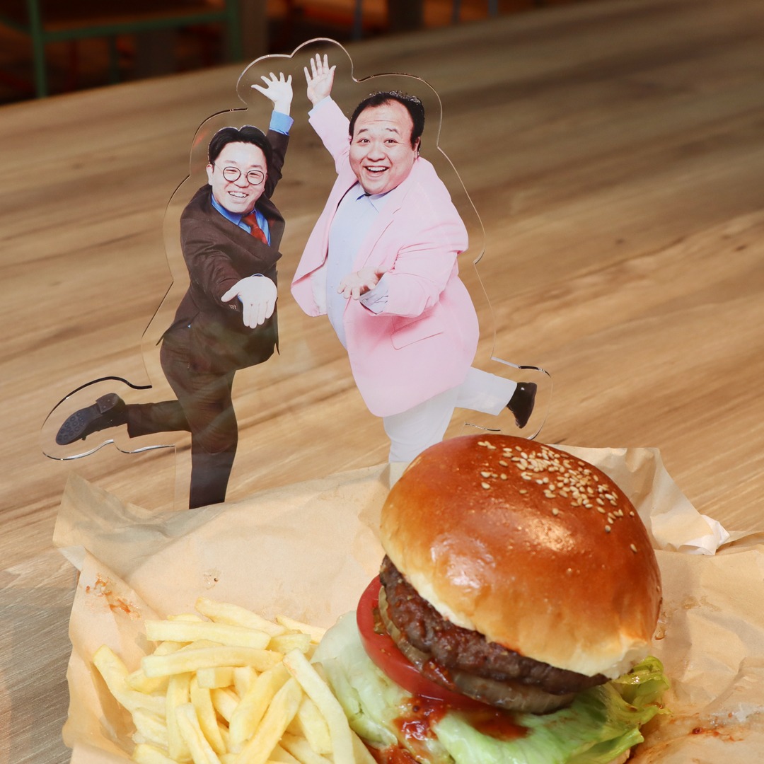 ハンバーガーと並べたときの「ママタルト ビッグアクリルスタンド」。