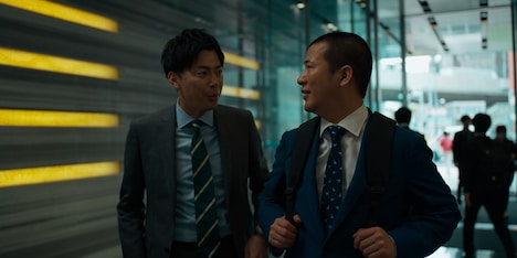 コットン西村扮する主人公の同僚(左)。