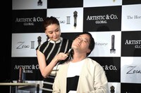 観月ありさ（左）に美顔器をあててもらうアインシュタイン稲田（右）。