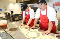 あっという間に生地を伸ばし終えた大鶴肥満さん（右）と、古巣のクセが出てしまう檜原さん（左）。