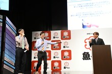 藤尾社長にツッコミを期待されていたが、大人しく説明を聞いていたおいでやす小田（中央）。