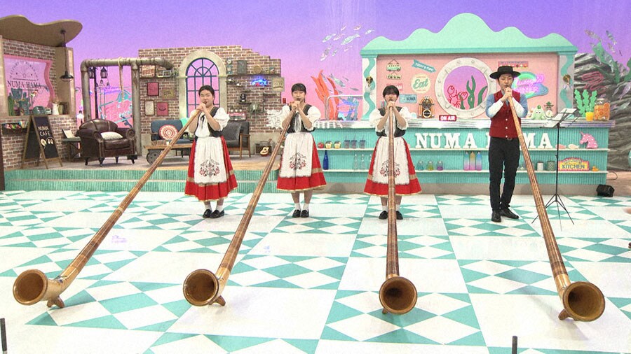アルプホルンの合奏に挑戦するトンツカタン森本。