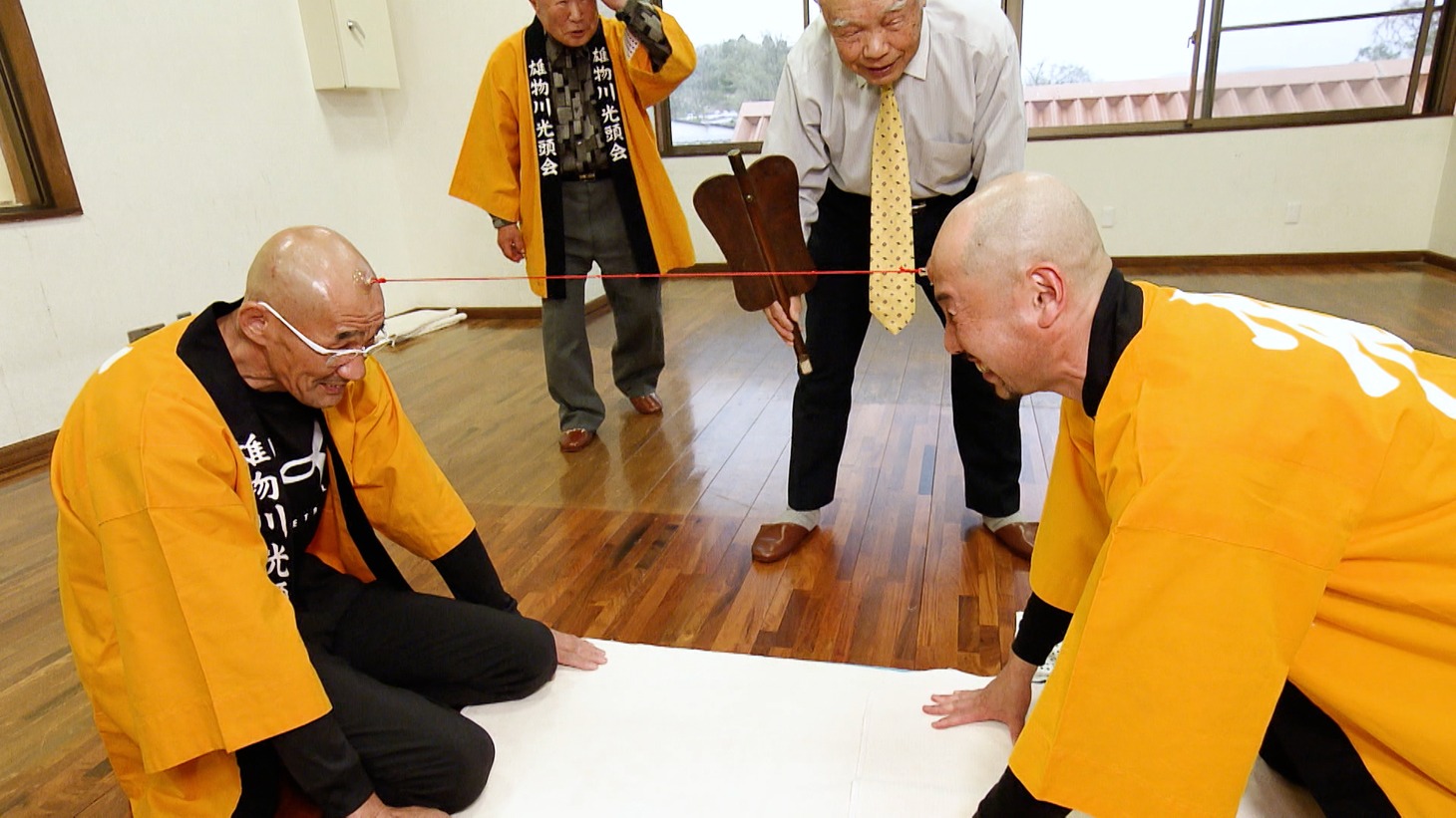 「吸盤綱引き」に挑む渡部陽一（手前右）。(c)ABCテレビ