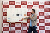 枕を頭に付けたまま年表を振り返るチョコレートプラネット長田。