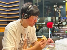 ハムサンドをほおばるロングコートダディ堂前。