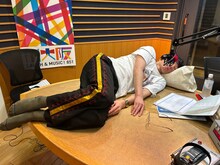 寝転んで録音するロングコートダディ堂前。