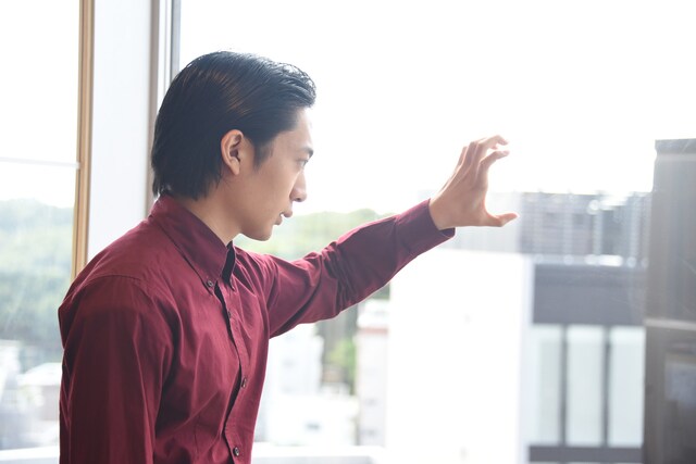 ビルからの景色を見下ろす友田オレ。