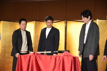 柳田悠岐選手の直筆サインが入った“ホームラン祈願バット”を眺める博多華丸・大吉。