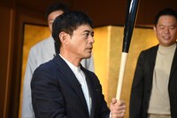 “ホームラン祈願バット”を見つめる博多華丸。