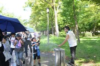 暑さでほてる参加者に水をかける見取り図・盛山。（写真提供：吉本興業）