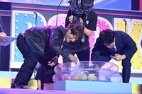 B'zを歌う権利をかけてヨーヨー釣り対決をする本並健治（左）と南波雅俊アナ（右）。