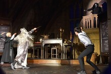 悪役・デスイーター（右後方）を、杖を用いて退治する霜降り明星せいや（手前左）。