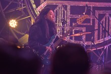 ドラマ「VIVANT」のチンギスの装いでベースを弾くレイザーラモンRG。