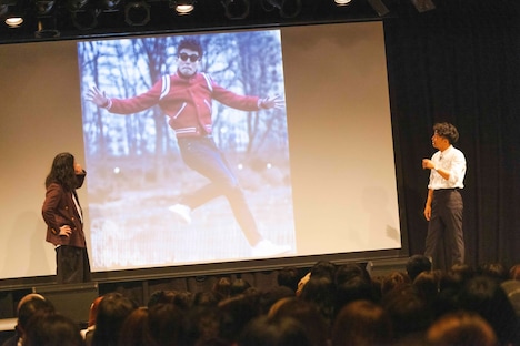 お気に入りの綾部の写真を紹介するピース又吉(左)。(c)吉本興業