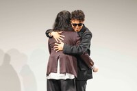 再会のハグを交わすピース。(c)吉本興業