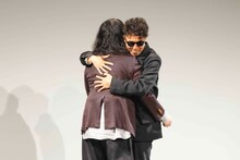 再会のハグを交わすピース。(c)吉本興業