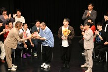 お祝いの花束を渡されるサルゴリラ。