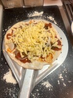 伸ばした生地にトマトソース、小さいハンバーグ、チーズの順に乗せ、焼く。