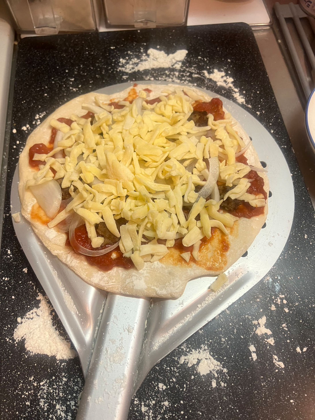 伸ばした生地にトマトソース、小さいハンバーグ、チーズの順に乗せ、焼く。