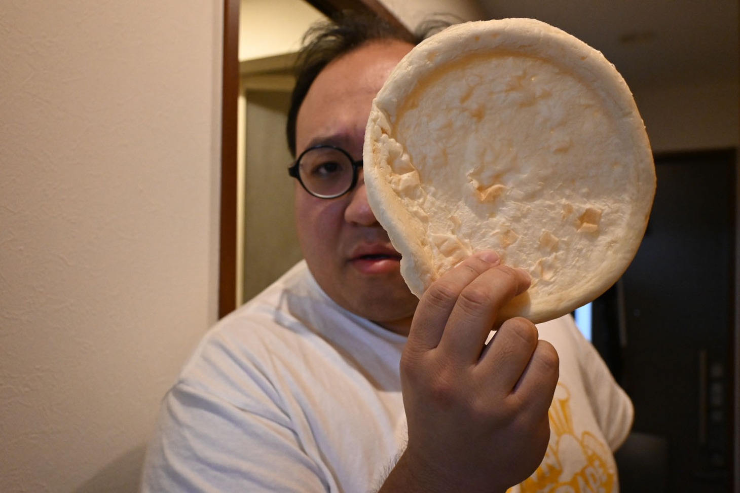 ピザ生地をお面のようにする大鶴肥満。（撮影：檜原洋平）