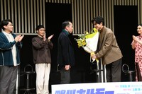 直木賞を受賞した万城目学へ中川大輔から花束を贈呈した場面。