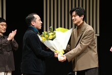 直木賞を受賞した万城目学へ花束を贈呈する中川大輔。