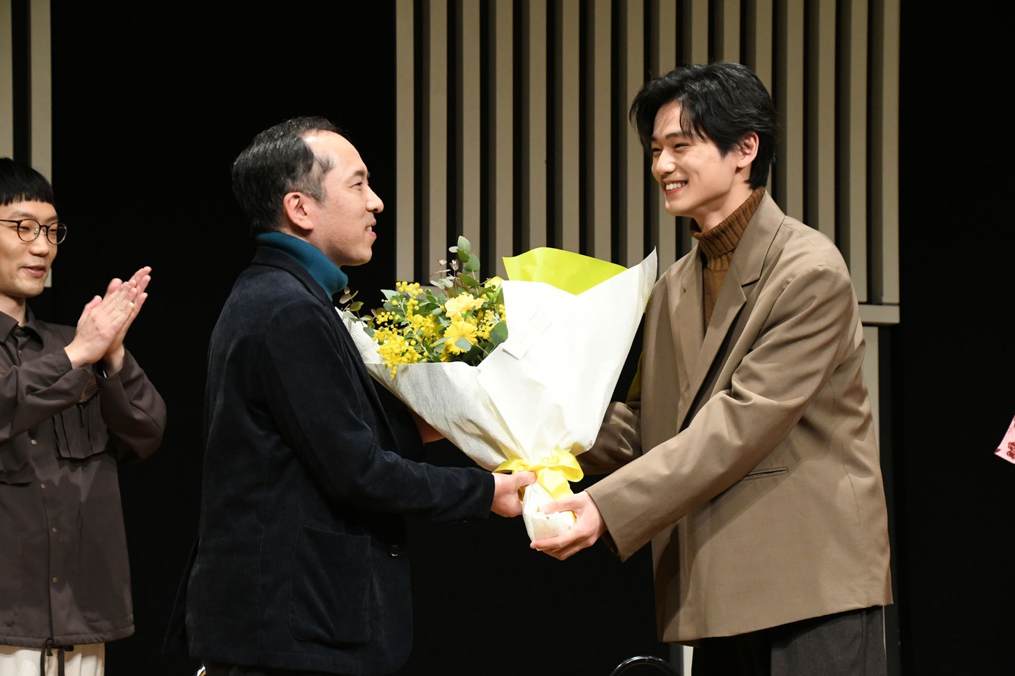 直木賞を受賞した万城目学へ花束を贈呈する中川大輔。