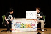 阪本に言いたいことを紙芝居にして伝えるマユリカ中谷（右）。（写真提供：吉本興業）