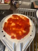 伸ばした生地にソースをかける。