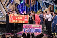 賞品が書かれたボードを受け取る街裏ぴんく。(c)関西テレビ