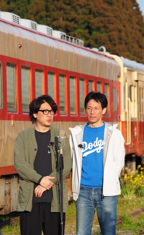 電車の車両をバックに漫才を披露する囲碁将棋。