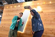 「バ」の看板の前で記念撮影するバナナマン。