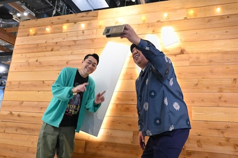 「バ」の看板の前で記念撮影するバナナマン。