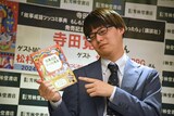 「本にツッコむようなポーズで」というリクエストに応える寺田寛明。