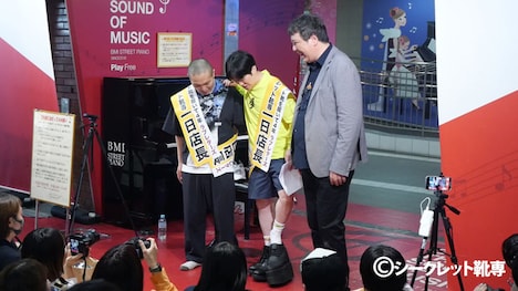 開発途中だという、20cm身長が高くなる靴を試す溜口。