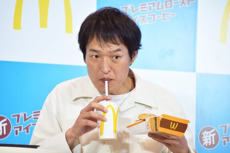 ビッグマック片手にプレミアムローストアイスコーヒーを試飲する千原ジュニア。