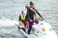 水面から引き上げられる久地々ディレクター（ジャルジャル後藤）。(c)Daichi Mononobe／Red Bull Flight Day