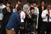 トロフィーを受け取る鯖のTシャツ・カンドウ。