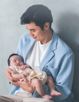 赤ちゃんモデルを抱っこする小島よしお。