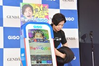 除幕式で筐体から取り去った暗幕を律儀に丸めてからスタッフに渡す野田クリスタル。