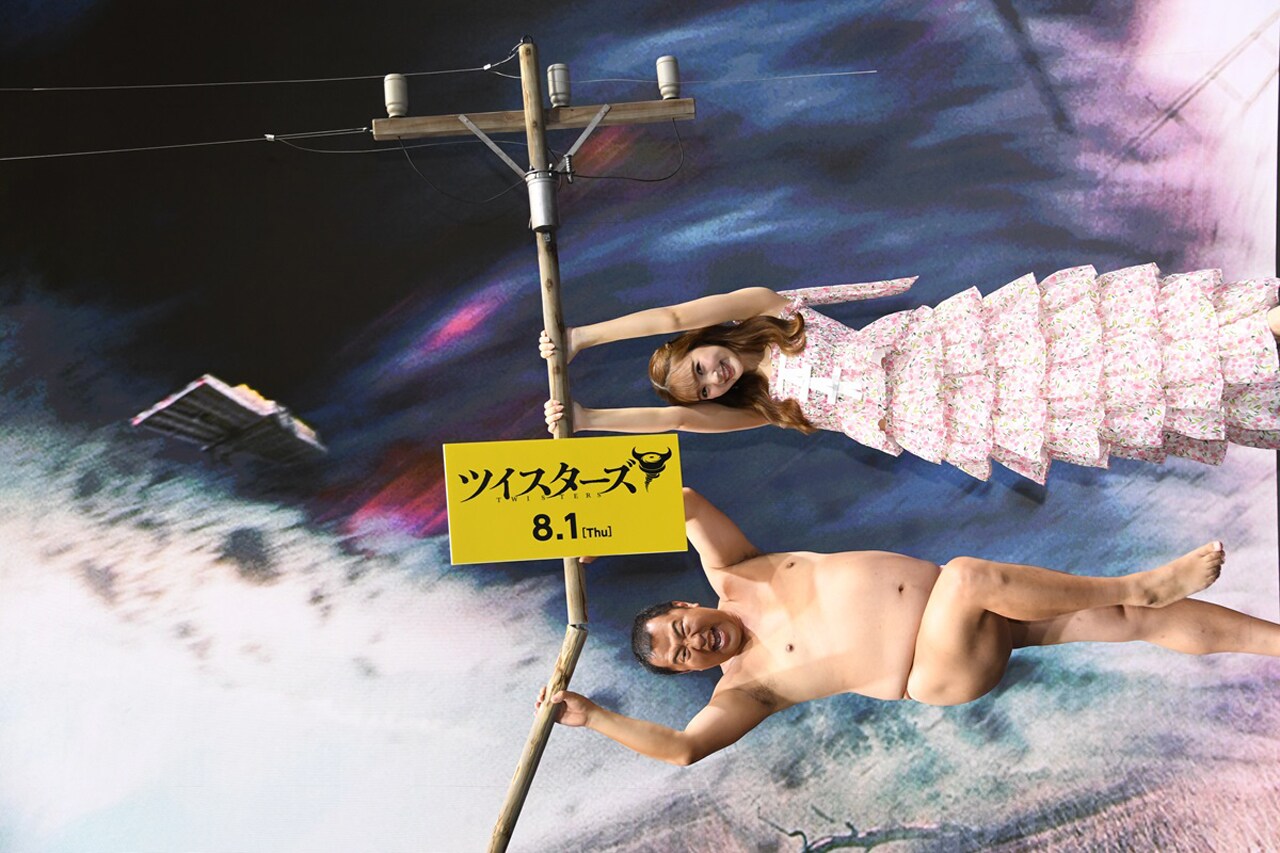 映画「ツイスターズ」宣伝サポーターのとにかく明るい安村と藤田ニコル。写真は竜巻に飛ばされているように見える向きになっている。（写真提供：アンリミテッド）