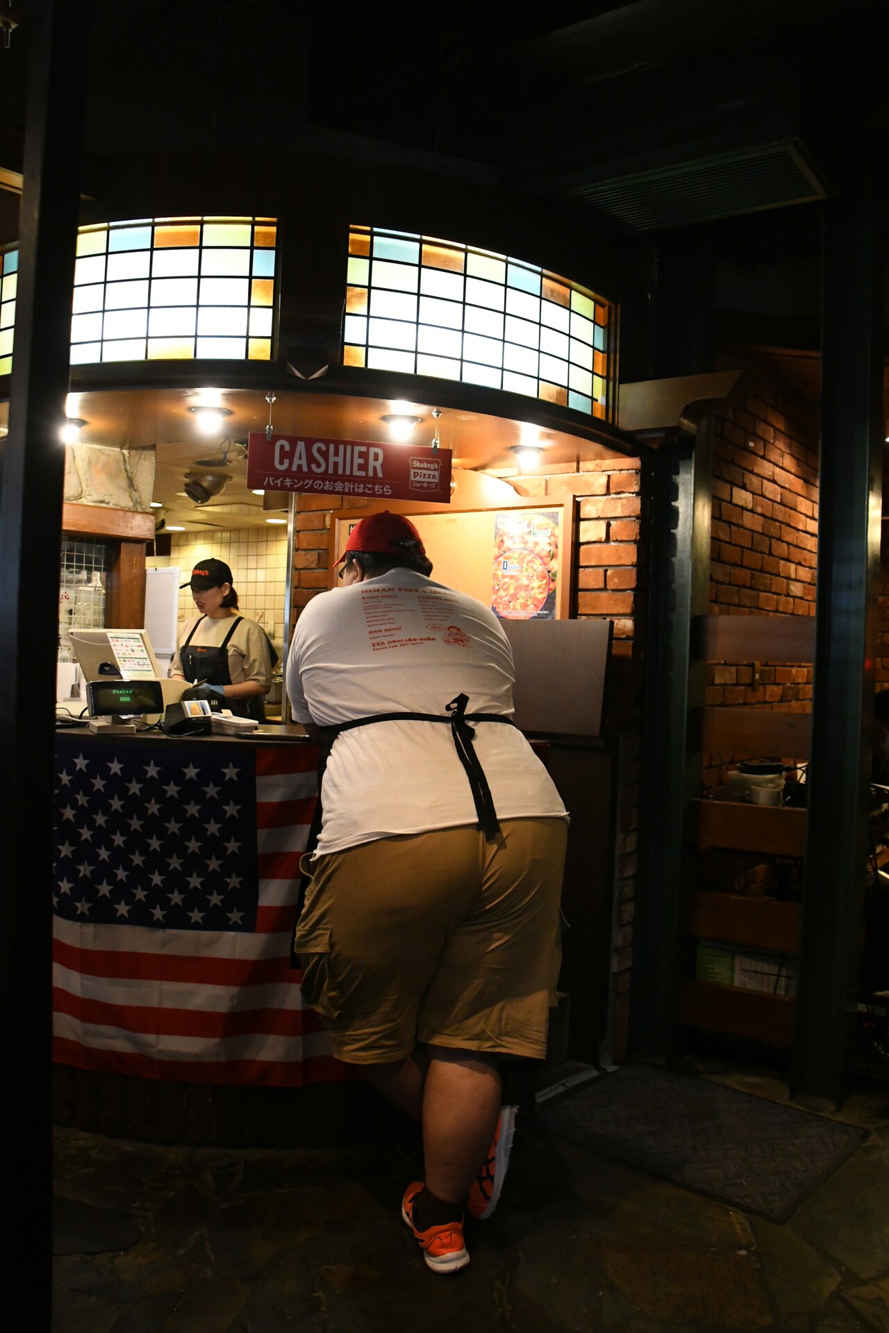 レジカウンターにて、大鶴肥満さんの後ろ姿。