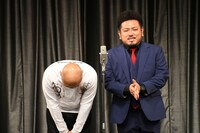 幕が開き、深々と長くおじぎする鬼越トマホーク坂井（左）。