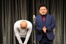 幕が開き、深々と長くおじぎする鬼越トマホーク坂井（左）。
