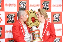 トロフィーにキスするようリクエストされるラブレターズ。