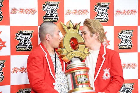 トロフィーにキスするようリクエストされるラブレターズ。