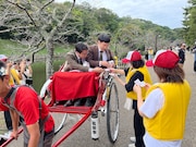 人力車に乗って名刺を配り回る男性ブランコ（写真提供：吉本興業）