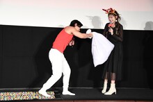 映画「レッド・ワン」公開記念イベントで足つぼマットを経てゆうちゃみにプレゼントを渡すマヂカルラブリー・野田クリスタル