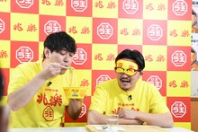 猫舌の伊藤に「日清ラ王 兆楽監修広東麺」を食べさせるため、ふーふーしてやるオズワルド畠中（左）