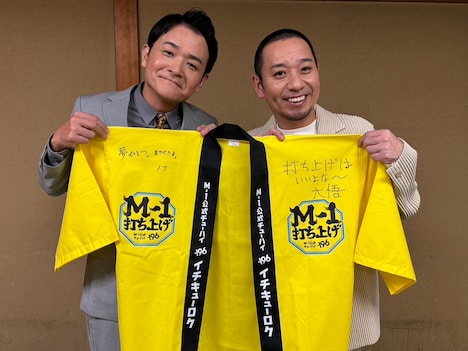 新幹事のマヂカルラブリーと渋谷凪咲にメッセージ入りの法被を贈る初代幹事・千鳥